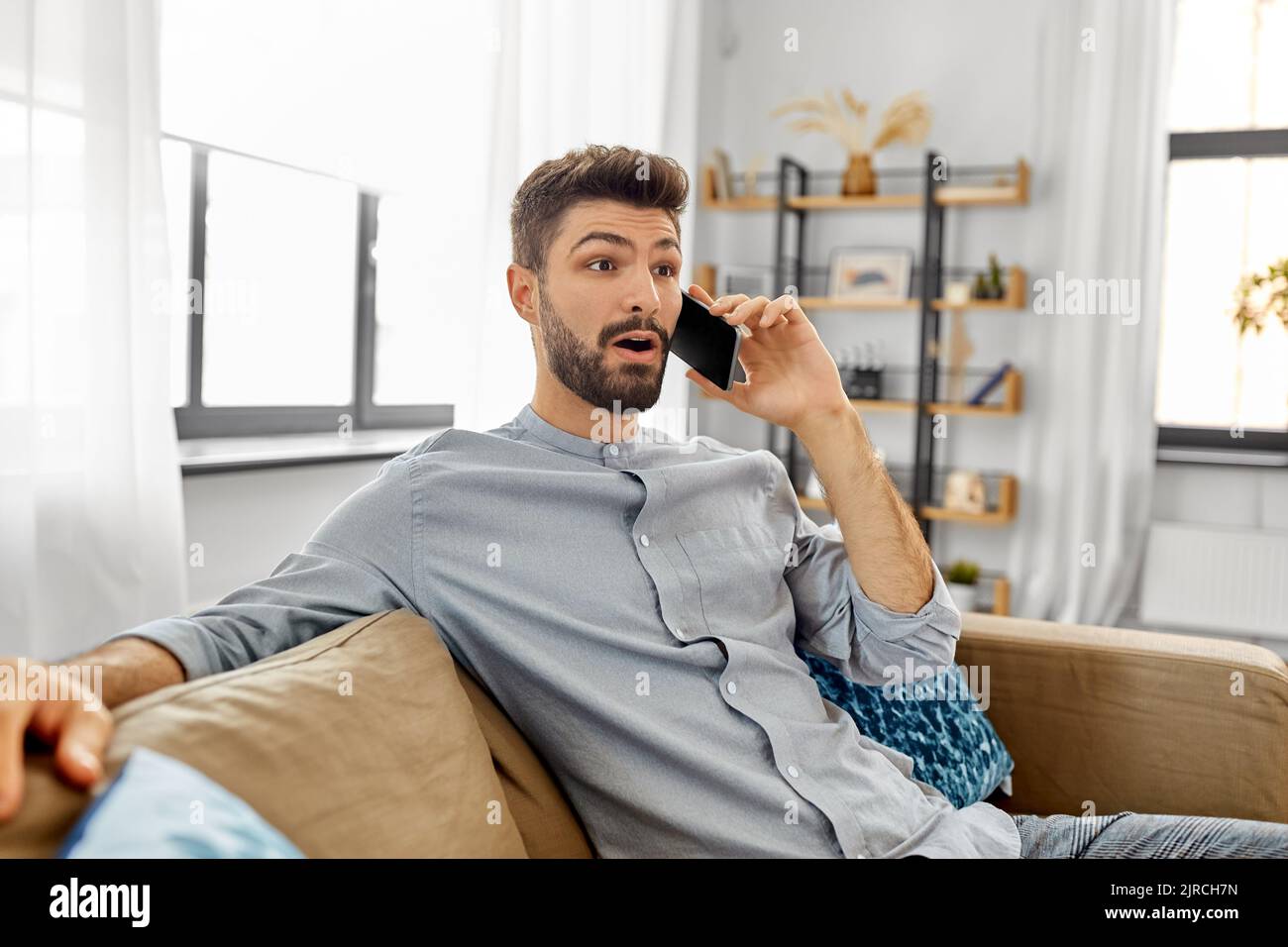 man calling on smartphone at home Stock Photo