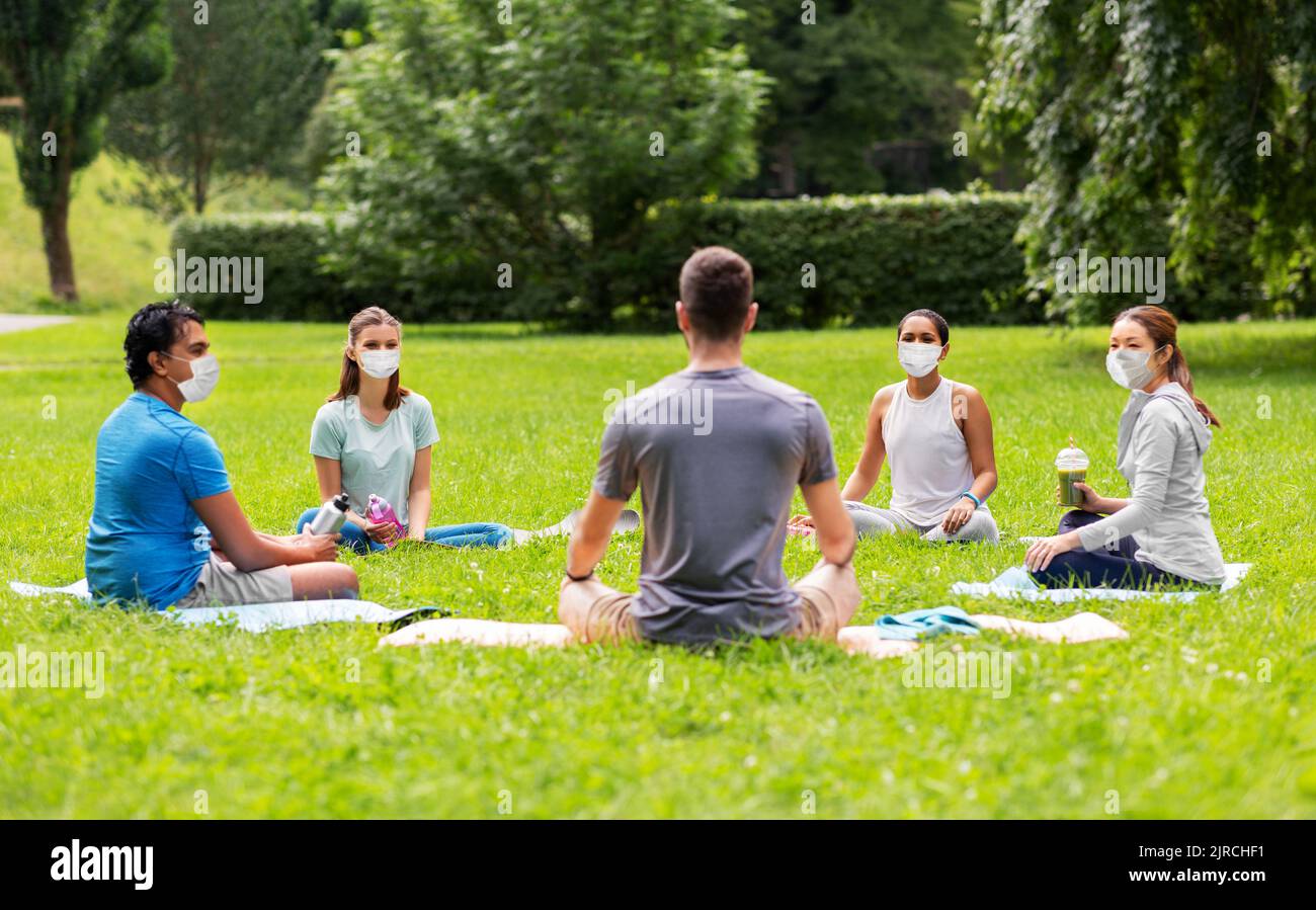 group of people sitting on yoga mats at park Stock Photo Alamy