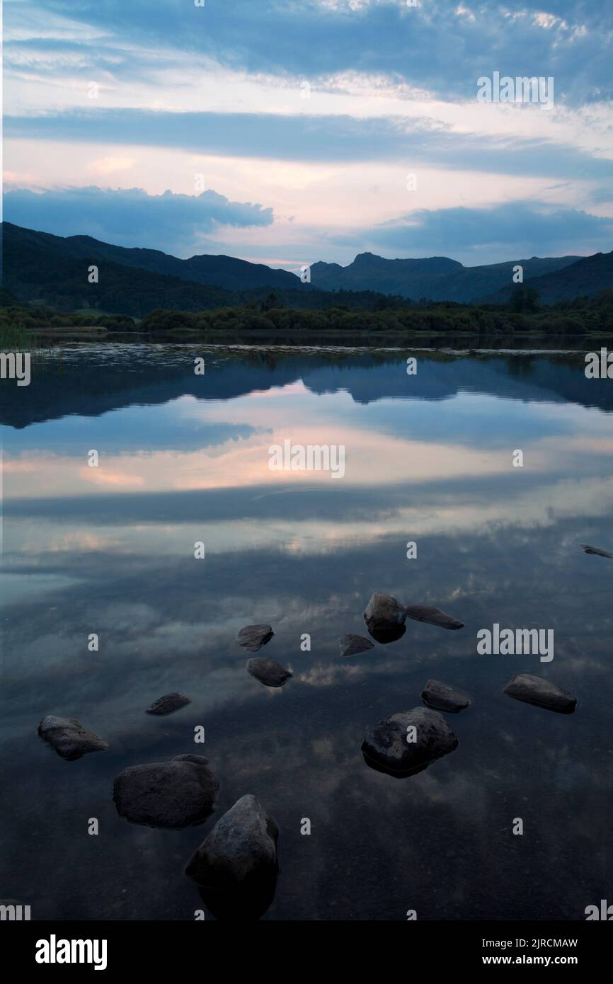 Langdale Pikes reflected in Elter Water Lake at sunset in the English Lake District Stock Photo