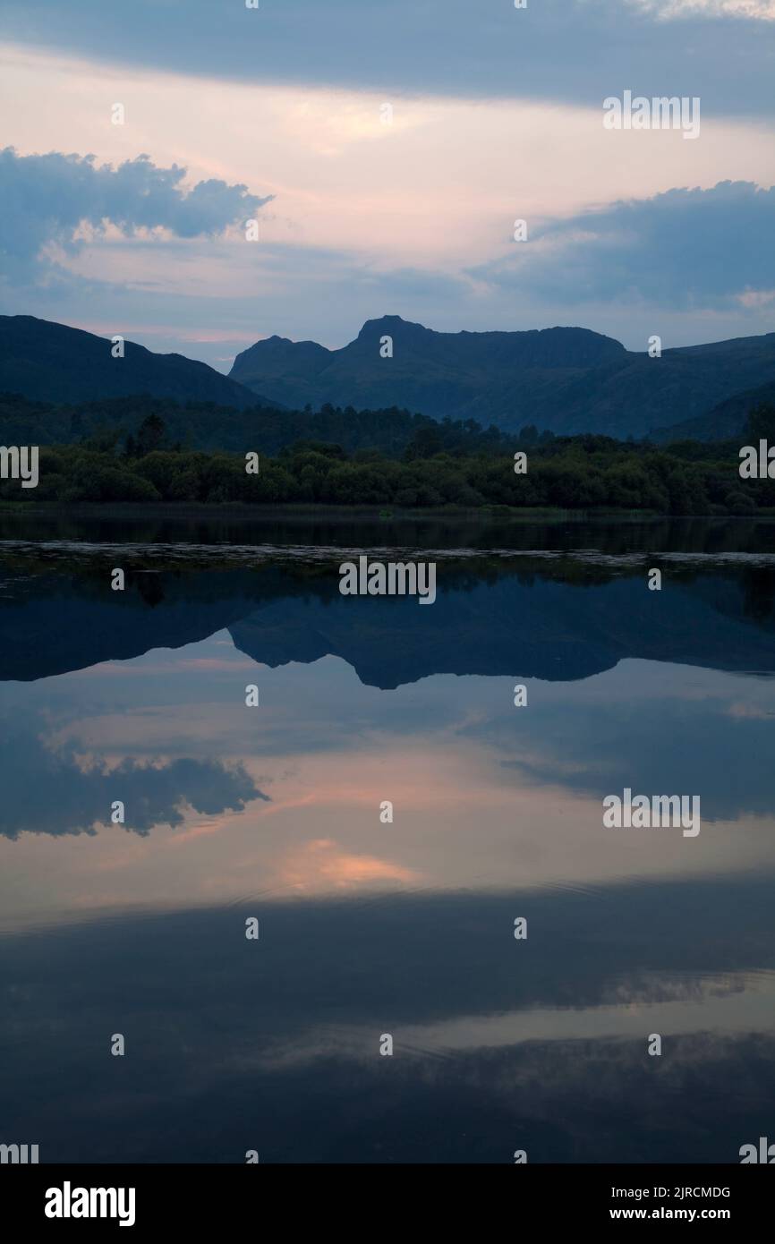 Langdale Pikes reflected in Elter Water Lake at sunset in the English Lake District Stock Photo