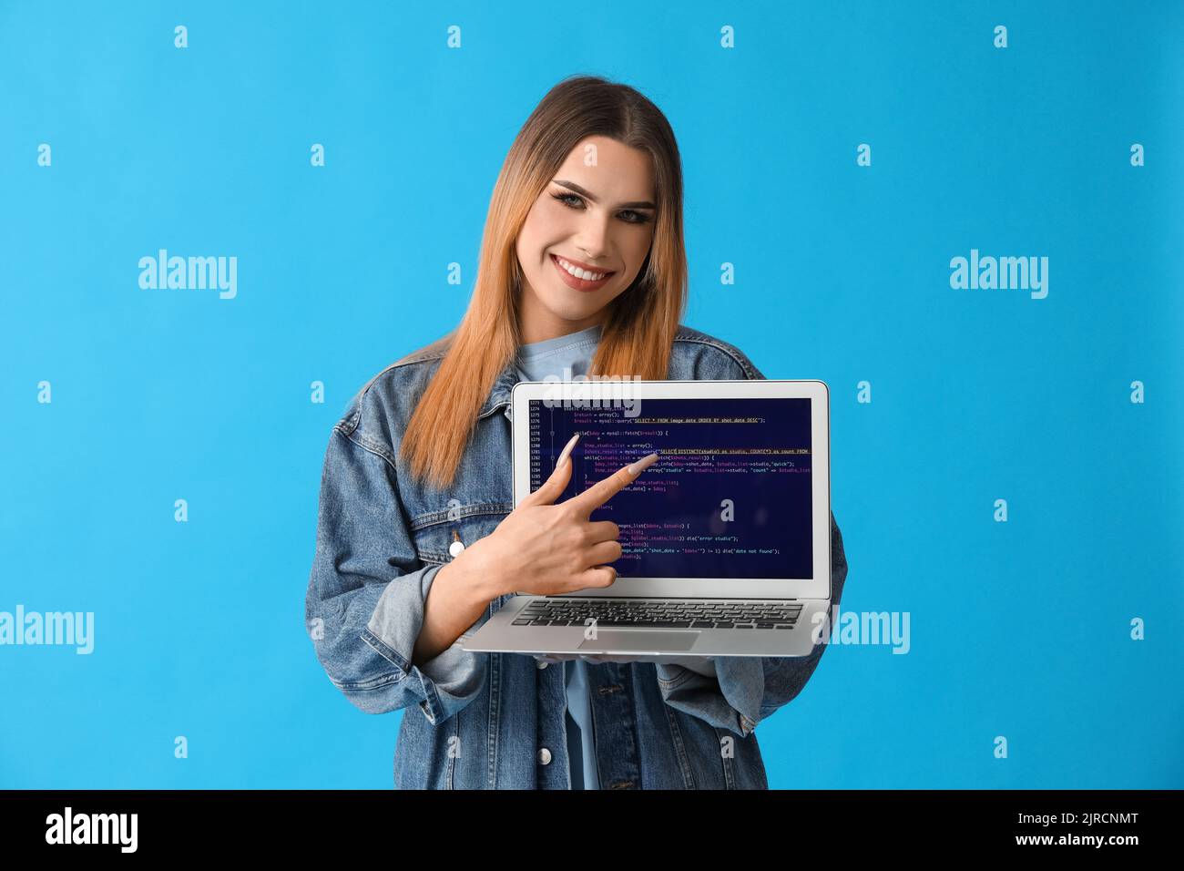 Transgender programmer with laptop on blue background Stock Photo - Alamy