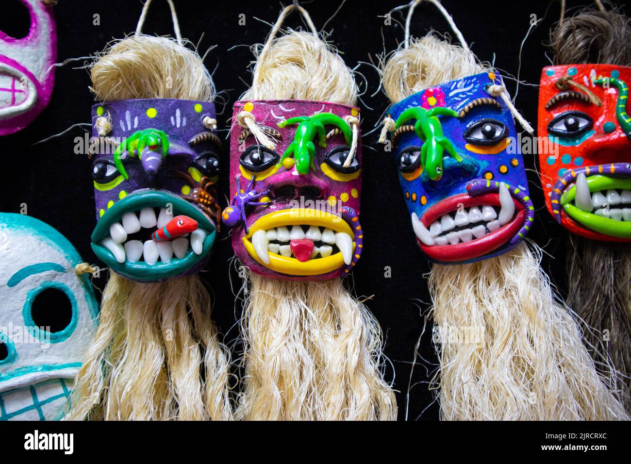colorful mexican tiki style day of the dead mask with long beard of carnival of oaxaca adornment for sale in a traditional market as souvenir for tour Stock Photo