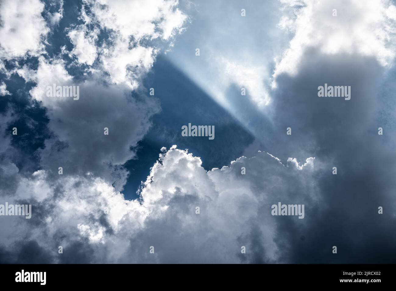 Dramatic shot of sun breaking through  stratocumulus clouds Stock Photo