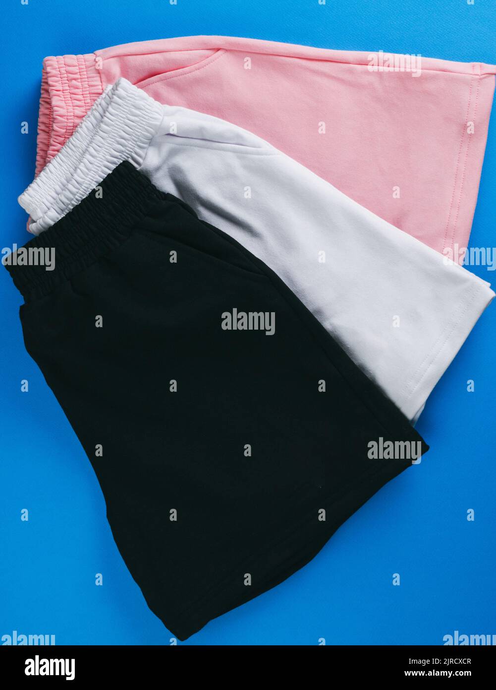 Basic Shorts Display A top view of a set of basic fabric shorts on a blue background ...