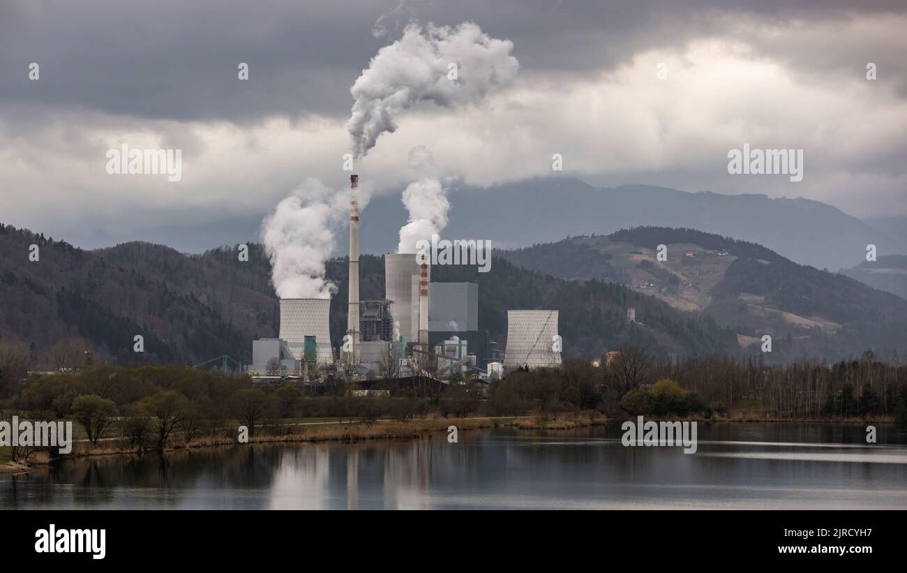 Thermal power plant burning coal with large cooling tower, emitting