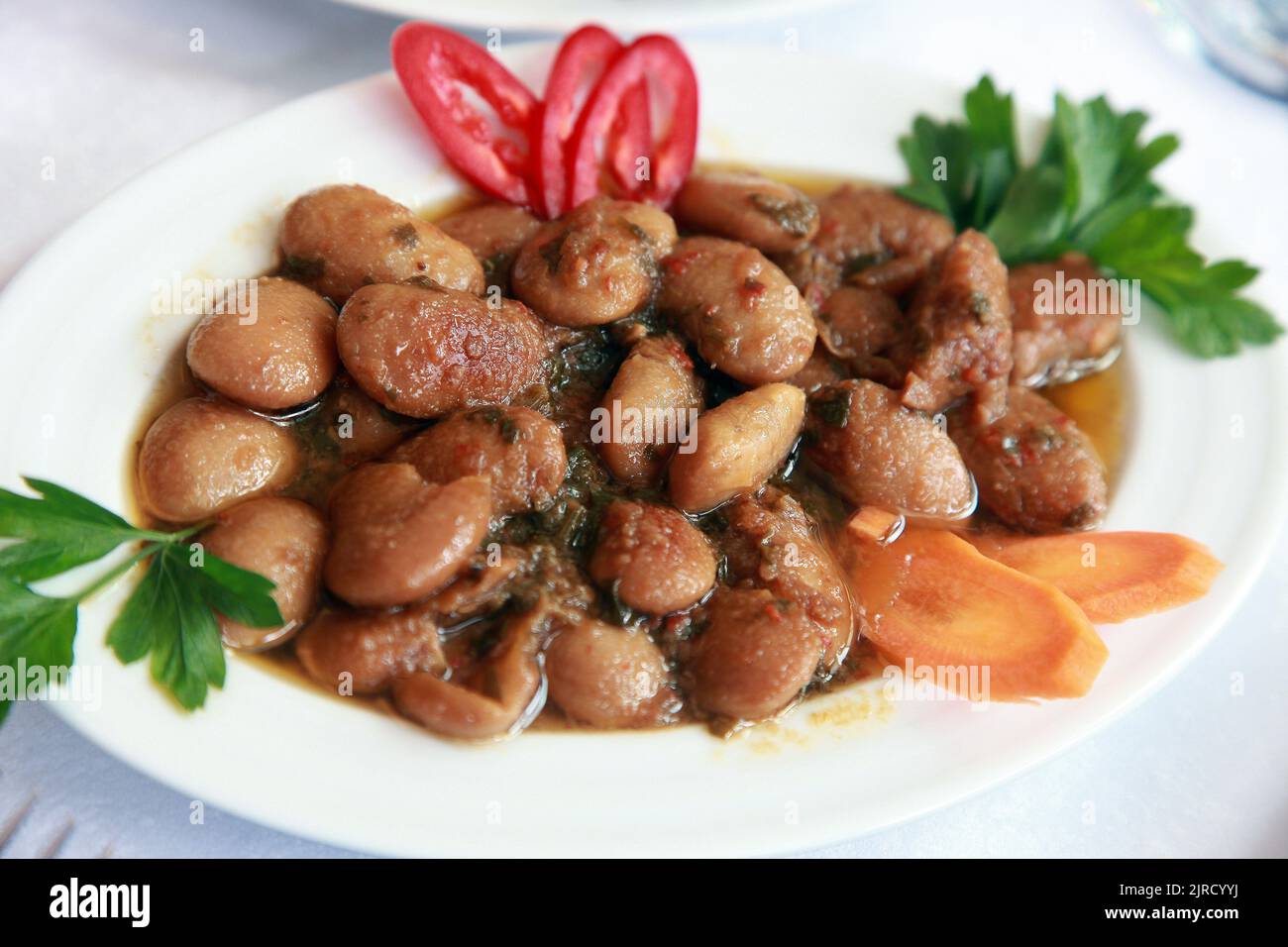 Turkish appetizer food 'Roman Bean' (Turkish: Barbunya Pilaki) on the dinner plate. Stock Photo