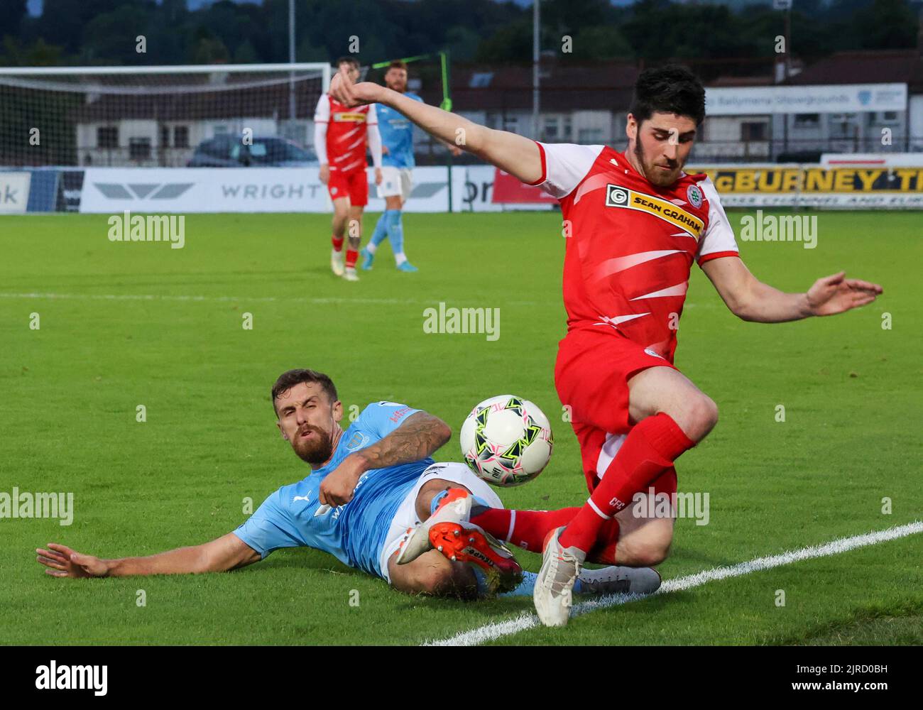 Ballymena Showgrounds, Ballymena, County Antrim,Northern Ireland, UK. 23 Aug 2022. Danske Bank Premiership – Ballymena United v Cliftonville (red). Action from tonight's game at The Showgrounds. Ballymena United's Stephen McCullough tackles Cliftonville's Kris Lowe. Credit: CAZIMB/Alamy Live News. Stock Photo