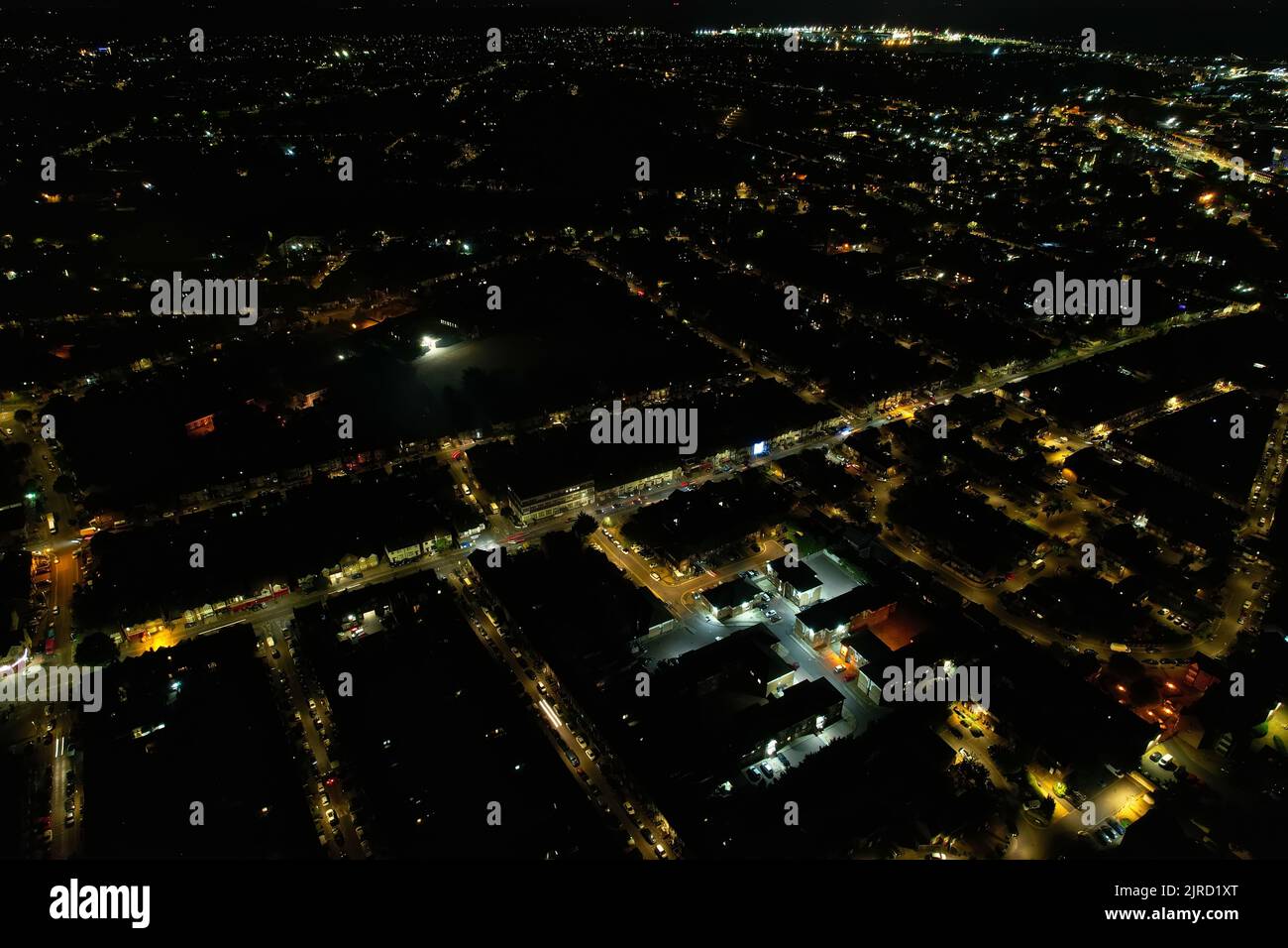 Aerial View Footage of British Houses, Illuminated Roads with Traffic on Motorways at England. High Angle Footage of British British City at Night. Stock Photo