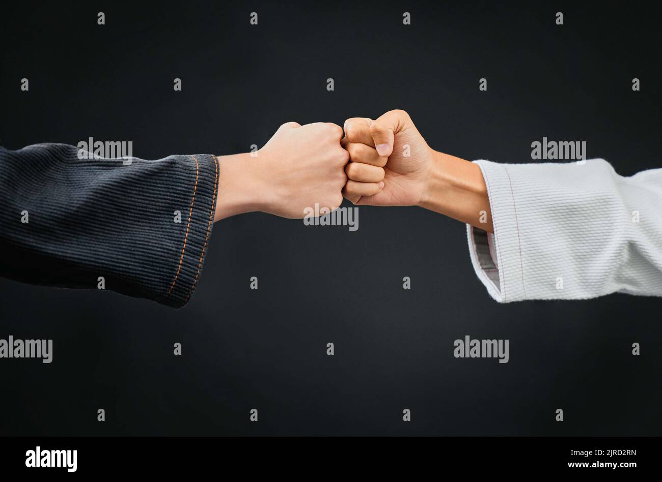 Teamwork, respect and discipline with hands fist bumping before a fight, match or mma competition. Closeup of two athletes greeting before combat Stock Photo