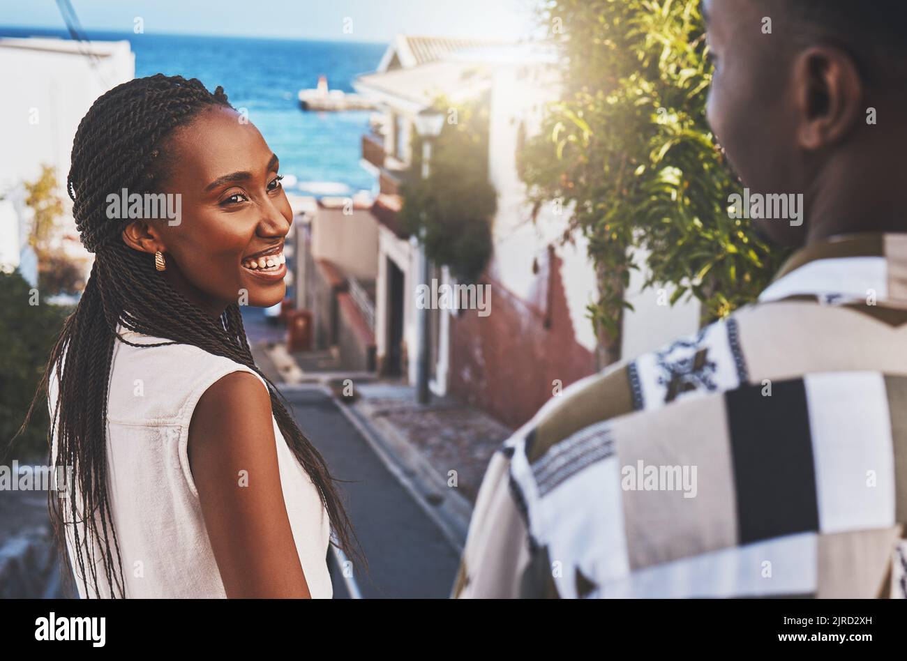 Love, travel and adventure with a young couple sightseeing together in a city by the sea during summer. Dating, romance and happiness with a beautiful Stock Photo