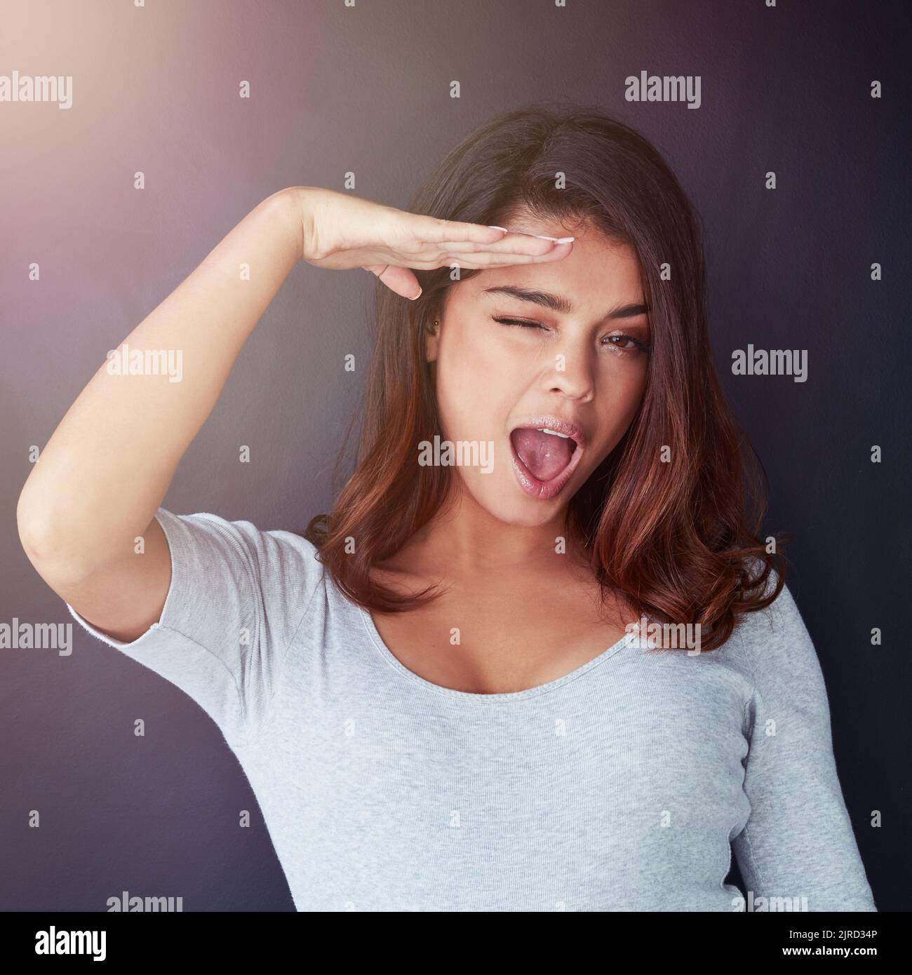 Aye aye, Captain. Cropped portrait of a beautiful young woman giving a salute and a wink in the studio. Stock Photo