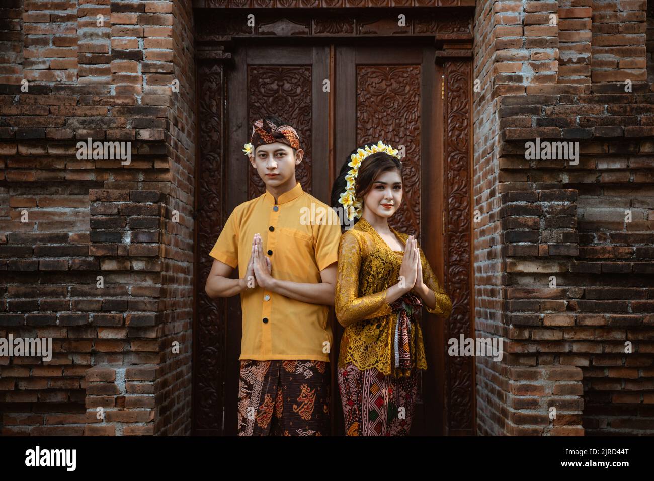 beautiful balinese couple portrait in front of the pura gate Stock Photo