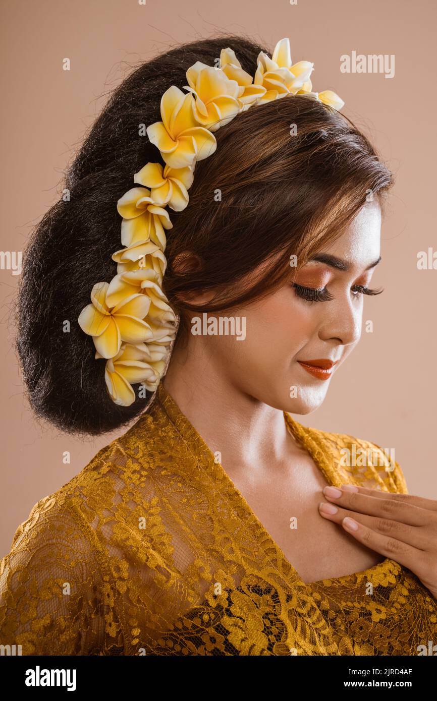 beautiful balinese woman in kebaya isolated over brown background Stock Photo