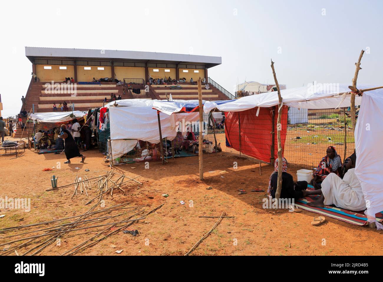 People rest inside a stadium after sustaining water damage to their houses during floods in Al-Managil locality in Jazeera State, Sudan August 23, 2022. REUTERS/Mohamed Nureldin Abdallah Stock Photo