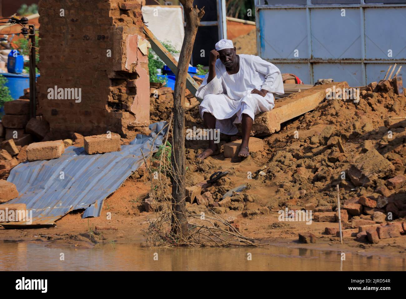A man rests after seeing the water damage to his house during floods in Al-Managil locality, in  Jazeera State, Sudan August 23, 2022. REUTERS/Mohamed Nureldin Abdallah Stock Photo