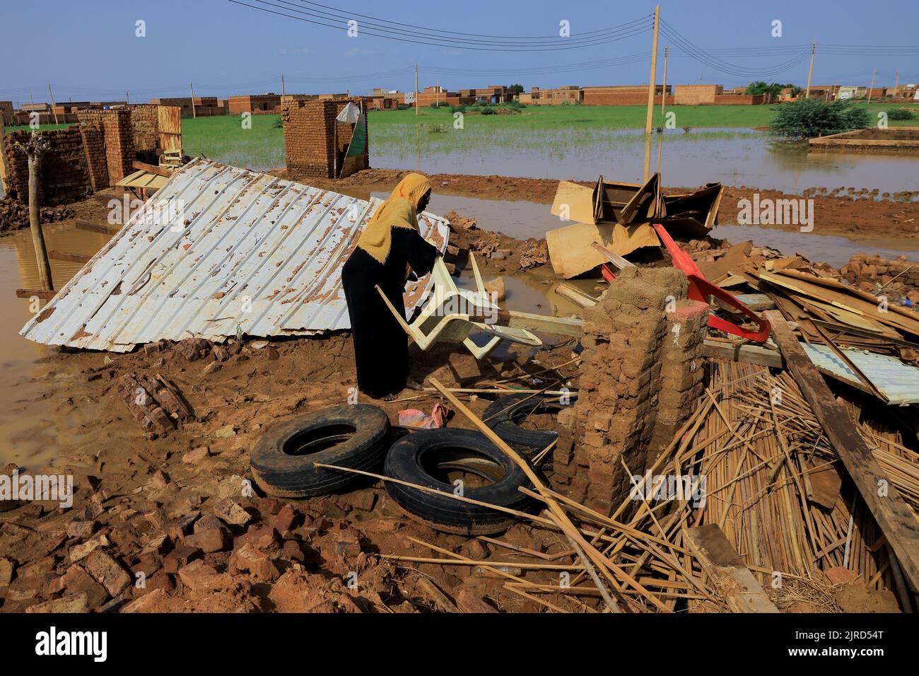A woman collects her belongings after sustaining water damage to her house during floods in Al-Managil locality, in Jazeera State, Sudan August 23, 2022. REUTERS/Mohamed Nureldin Abdallah Stock Photo