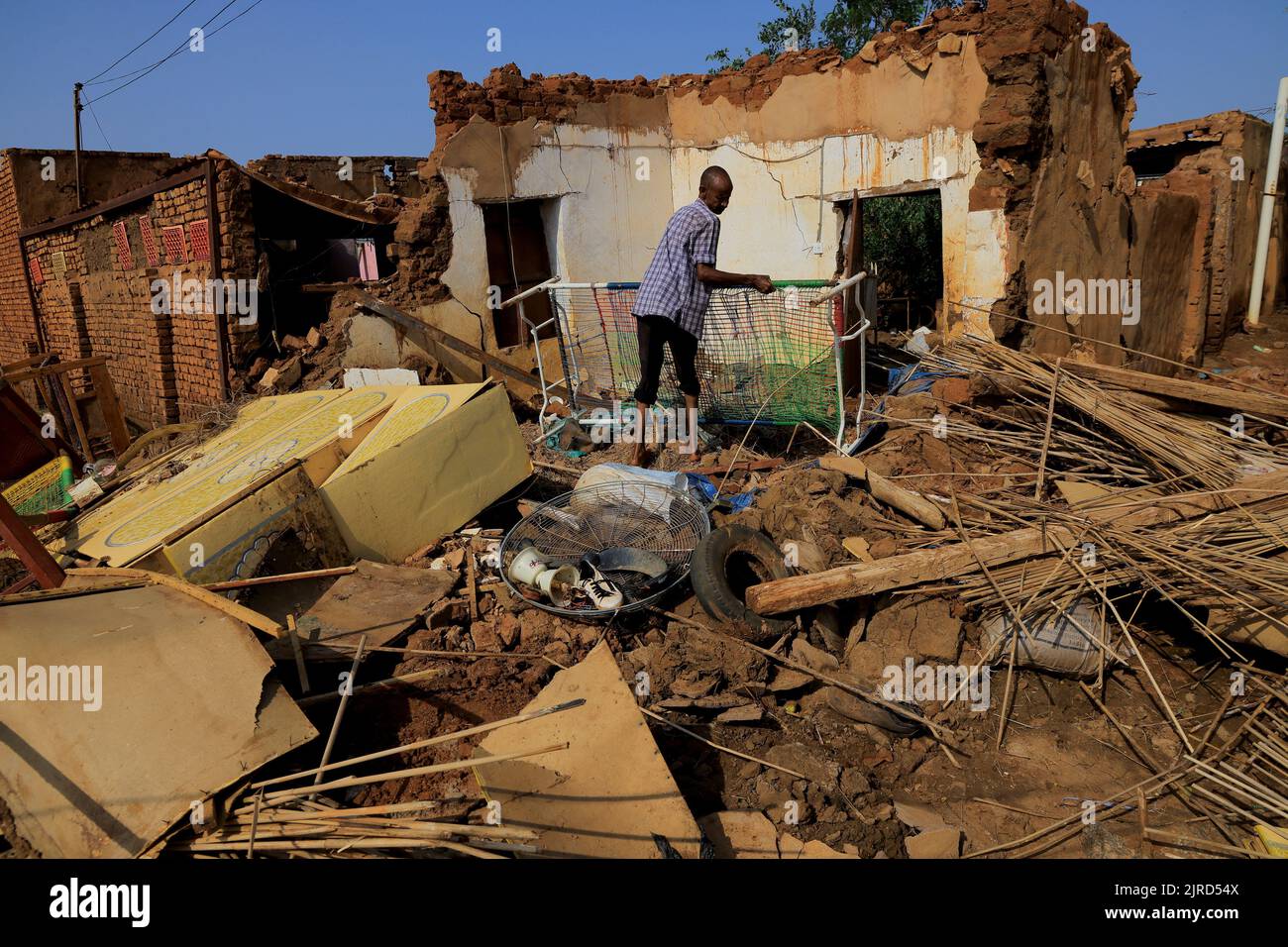 A man collects his belongings after sustaining water damage to his house during floods in Al-Managil locality, in Jazeera State, Sudan August 23, 2022. REUTERS/Mohamed Nureldin Abdallah Stock Photo