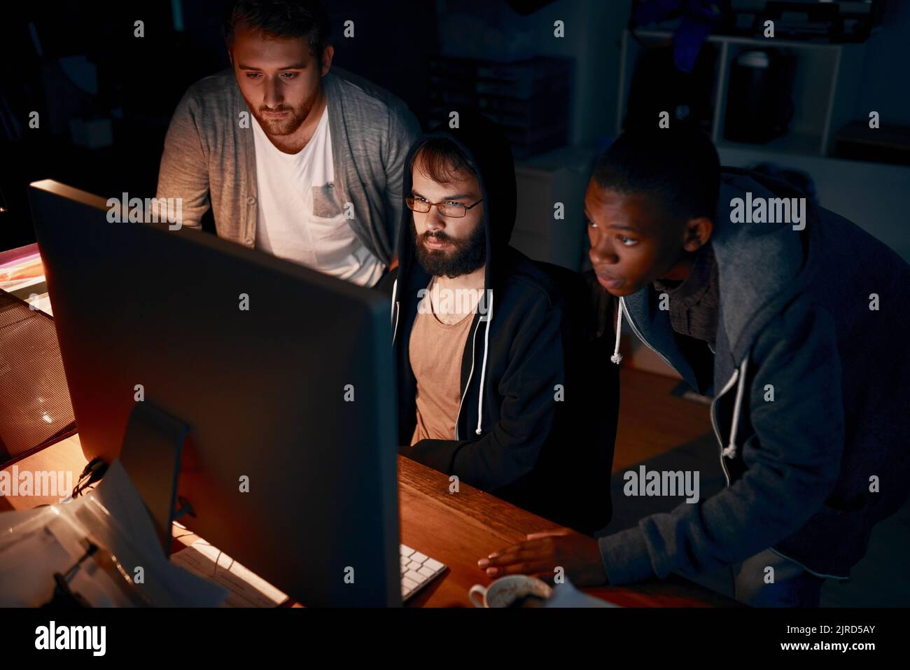 Focused on the code. young computer programmers working late in the office. Stock Photo