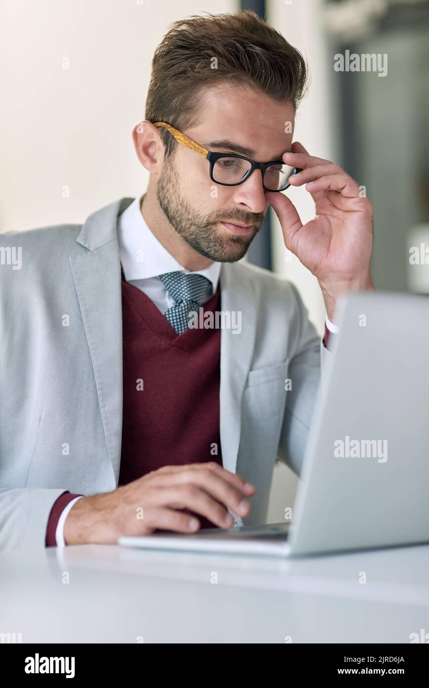 Hard work makes millions. a businessman using a laptop at his office desk. Stock Photo