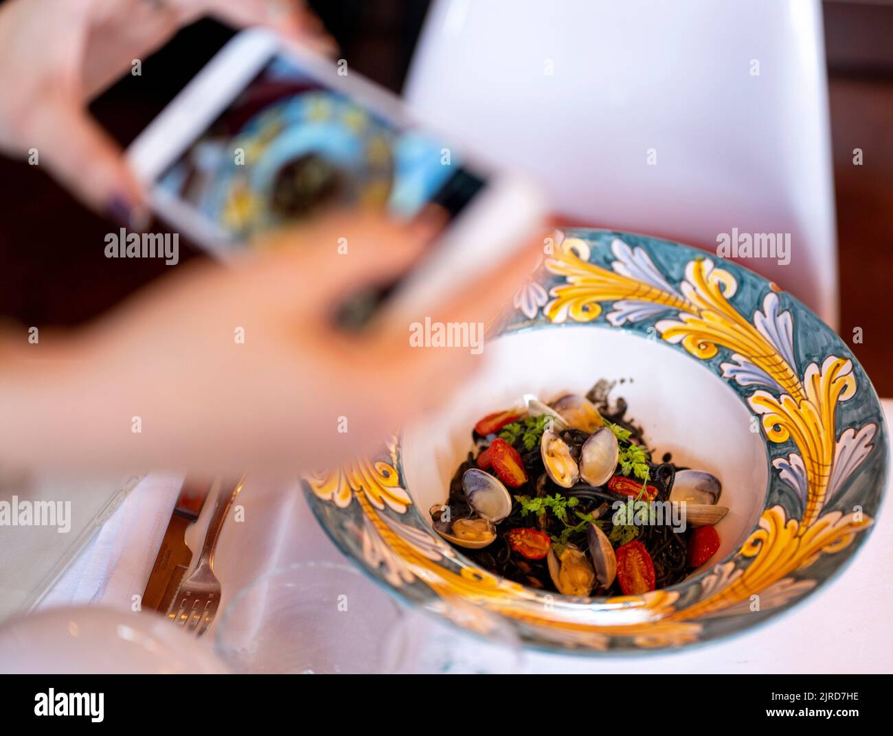 Berlin, Germany. 19th Aug, 2022. A woman takes a picture with her smartphone of the dish 'Drop it like it's hot' at the restaurant 'Coccodrillo' in Weinbergspark. The main thing 'Instagrammable' seems to be the motto of some new eateries. Credit: Monika Skolimowska/dpa/Alamy Live News Stock Photo