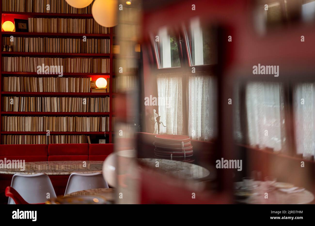 Berlin, Germany. 19th Aug, 2022. Numerous books stand on a shelf against the wall in the dining room of the 'Coccodrillo' restaurant in Weinbergspark. The main thing 'Instagrammable' seems to be the motto of some new eateries. Credit: Monika Skolimowska/dpa/Alamy Live News Stock Photo