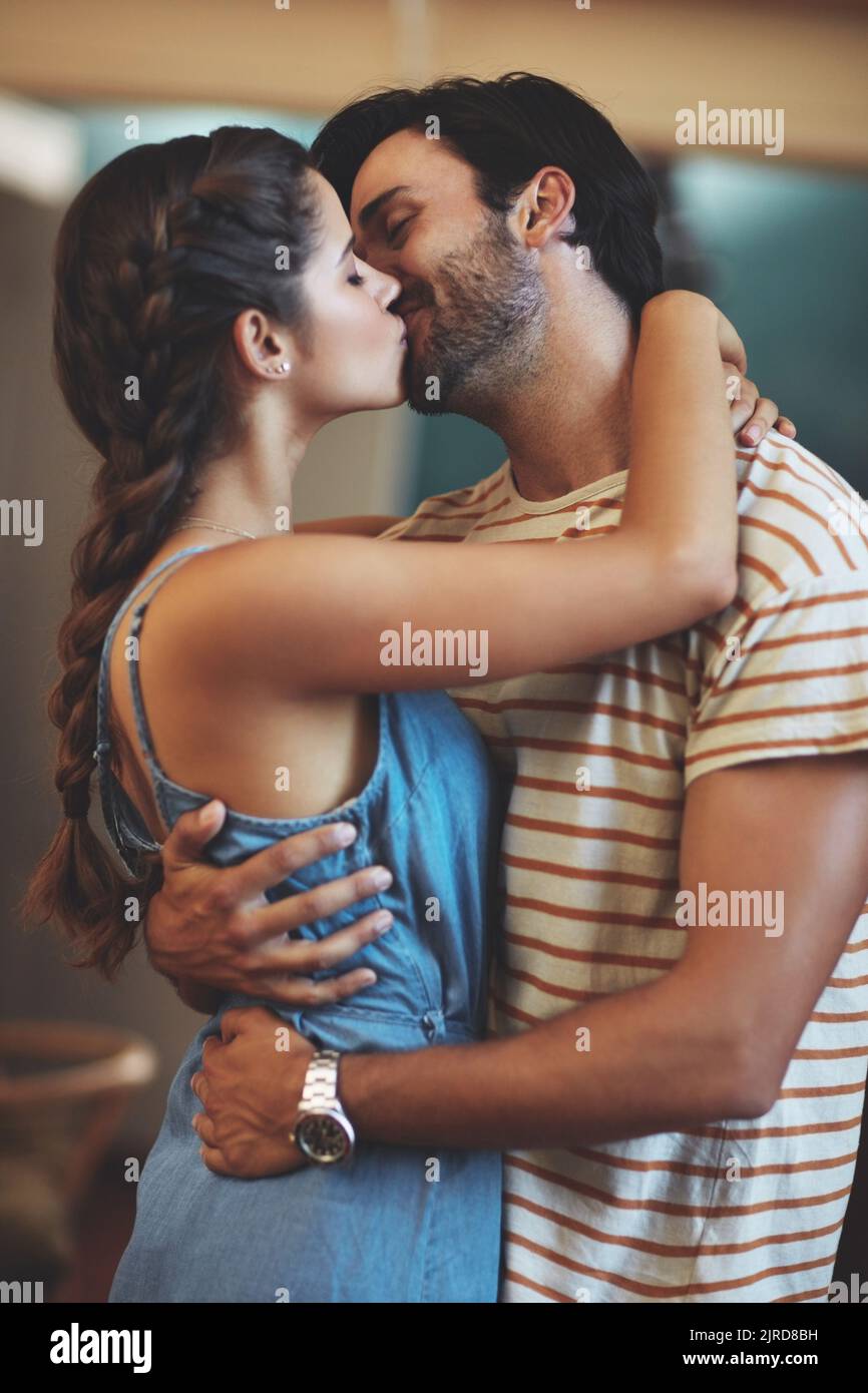 Your love gives me feelings Ive never felt before. an affectionate young couple kissing in their kitchen at home. Stock Photo