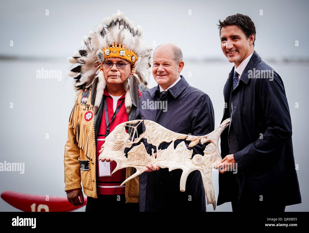 Stephenville, Canada. 23rd Aug, 2022. German Chancellor Olaf Scholz (M, SPD) and Justin Trudeau (r), Prime Minister of Canada, stand with Misel Joe, Chief of the First Nation Miawpukek, in Newfoundland with a decorated moose antler. The trip will focus on cooperation between the two countries on climate and energy. Credit: Kay Nietfeld/dpa/Alamy Live News Stock Photo