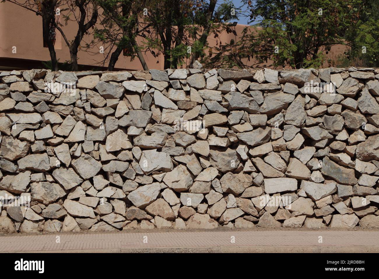 Hand made gray rough stonewall. Abstract stones textured background