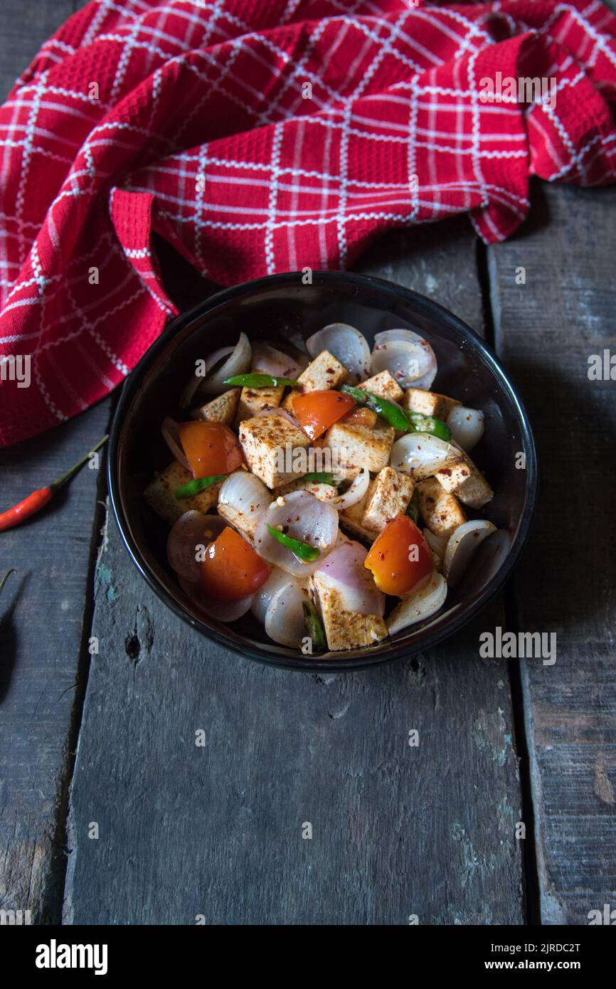 Paneer or cottage cheese cubes saute with veggies in a bowl Stock Photo