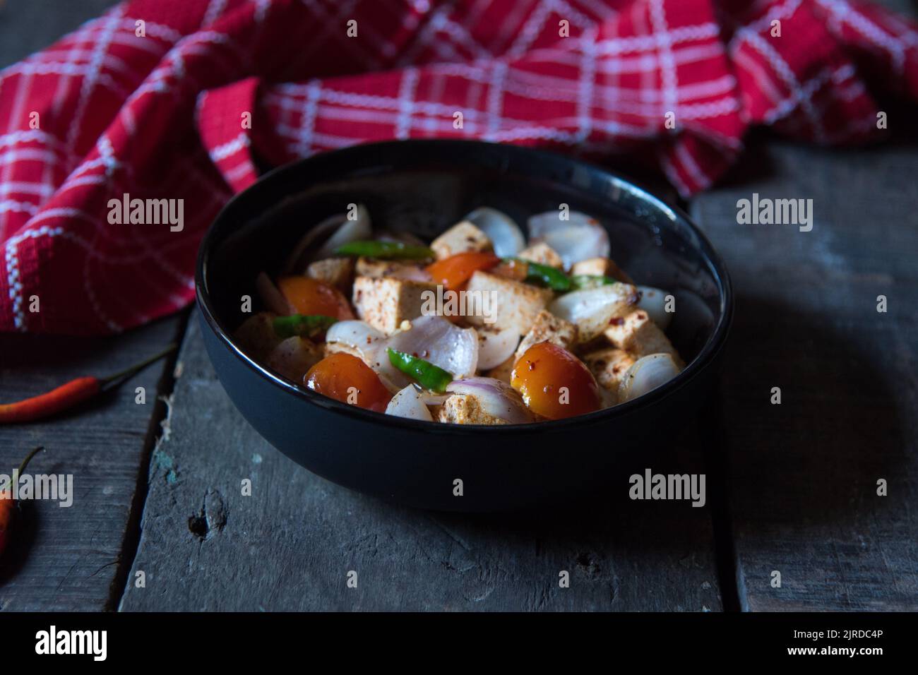 Paneer or cottage cheese cubes saute with veggies in a bowl Stock Photo