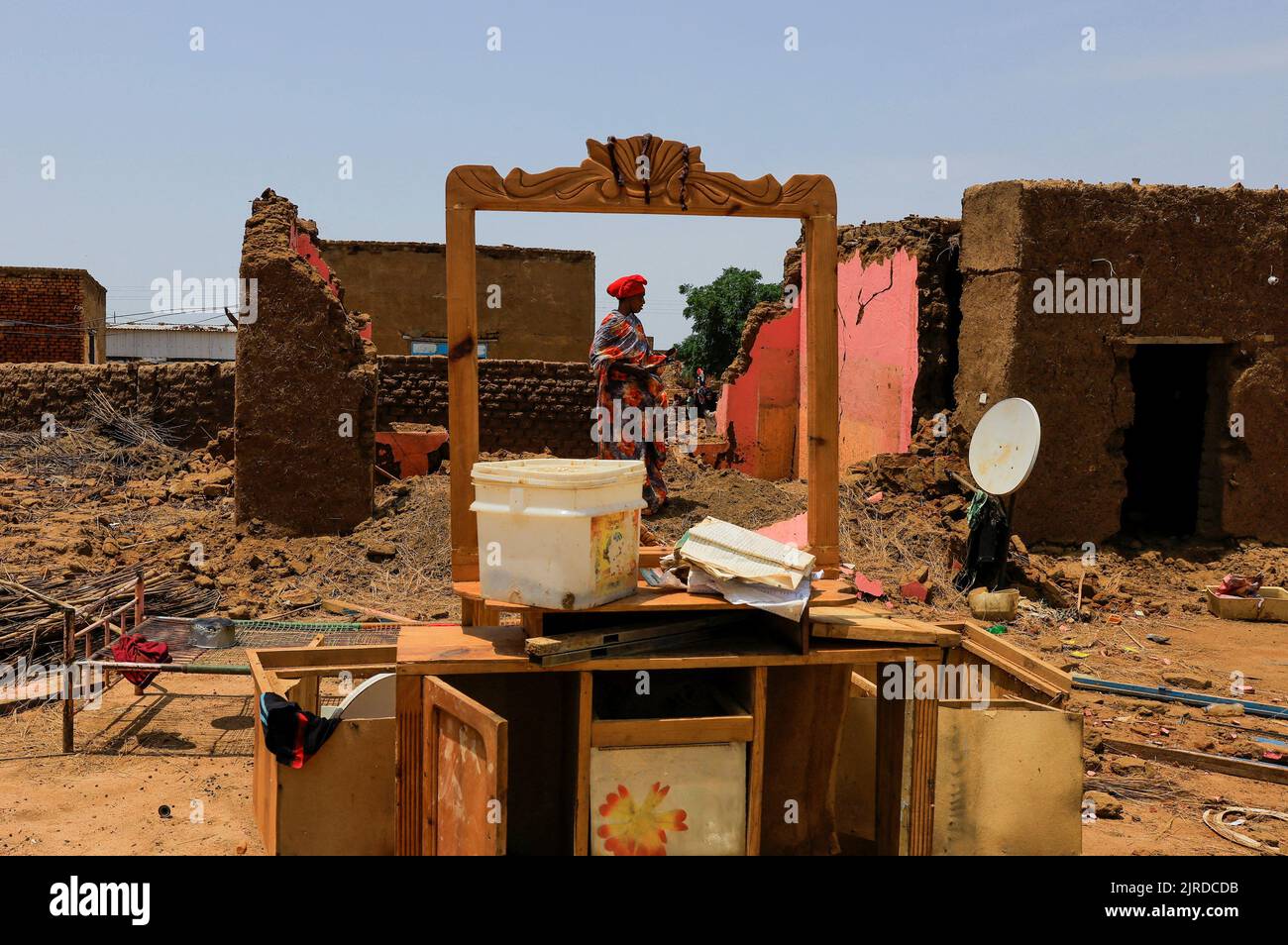 A woman collects her belongings after sustaining water damage to her house during floods in Al-Managil locality, in Jazeera State, Sudan August 23, 2022. REUTERS/Mohamed Nureldin Abdallah Stock Photo