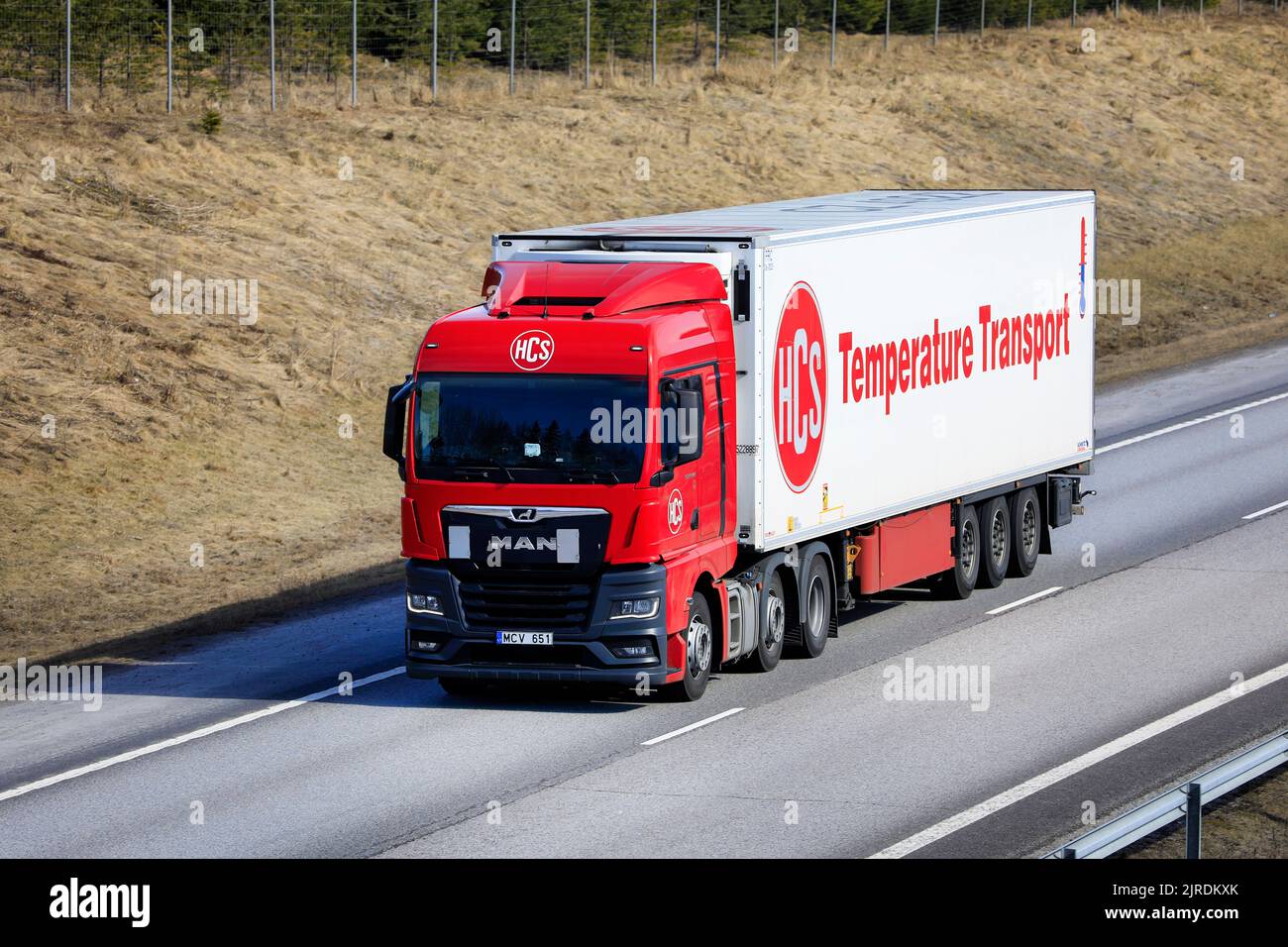 New, red MAN TGX 26.470 truck in front of FRC temperature controlled transport trailer on motorway in the spring. Salo, Finland. April 18, 2022. Stock Photo