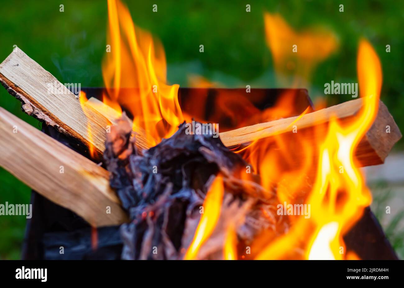Tongues of orange fire from burning wood sticks. Preparation of embers