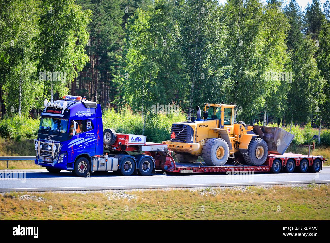 Volvo FH16 750 truck Nooteboom low loader trailer Lavettikuljetus Ylitalo & Vahtera Oy hauls Volvo L180E wheel loader. Salo, Finland. July 17, 2020. Stock Photo