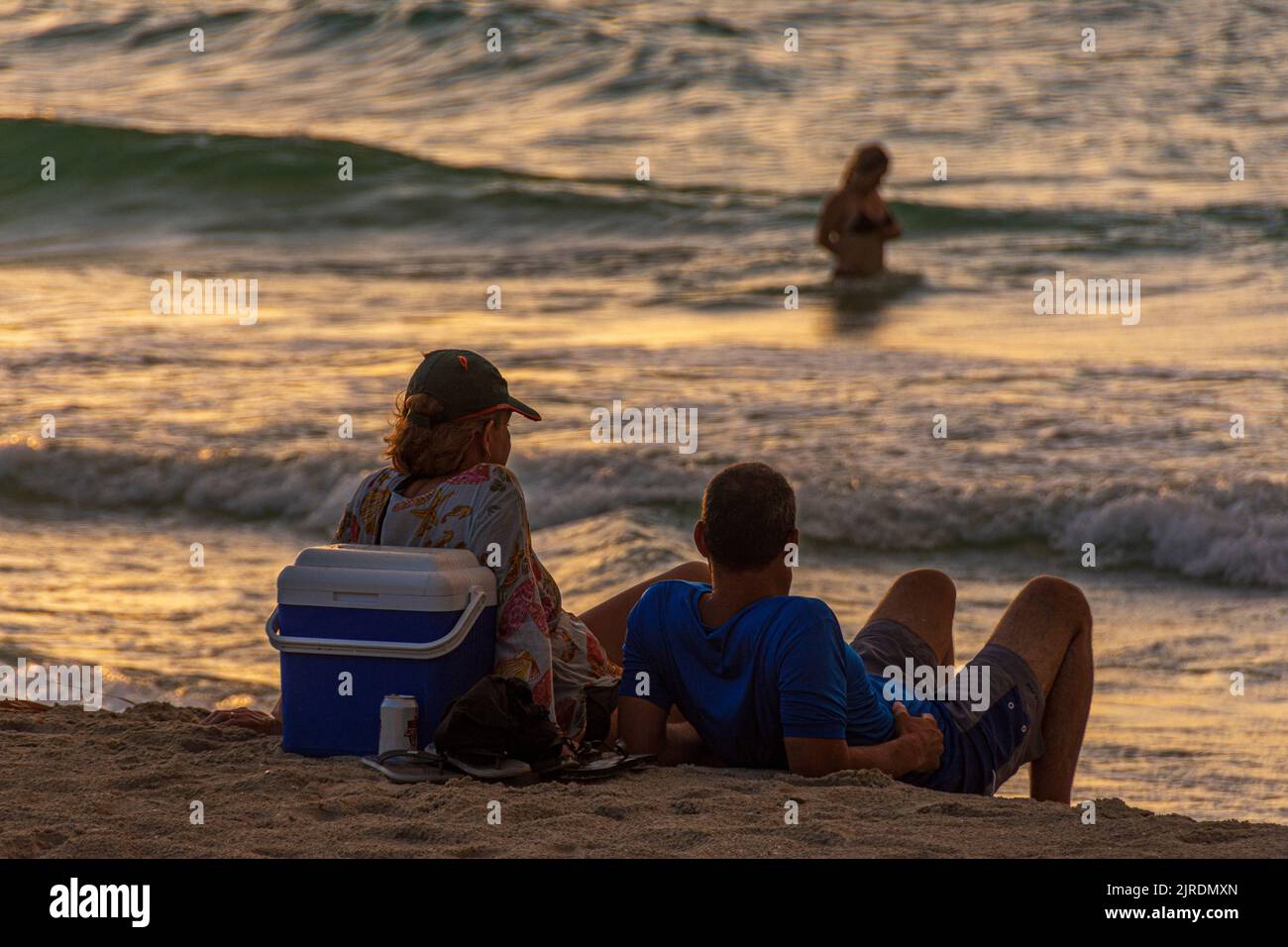 A couple in their early 30's enjoying chilling on the beach and watching the sun set, Varadero Stock Photo