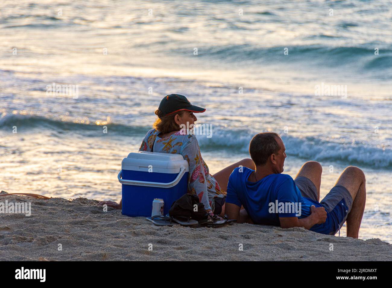 A couple in their early 30's enjoying chilling on the beach and watching the sun set, Varadero Stock Photo