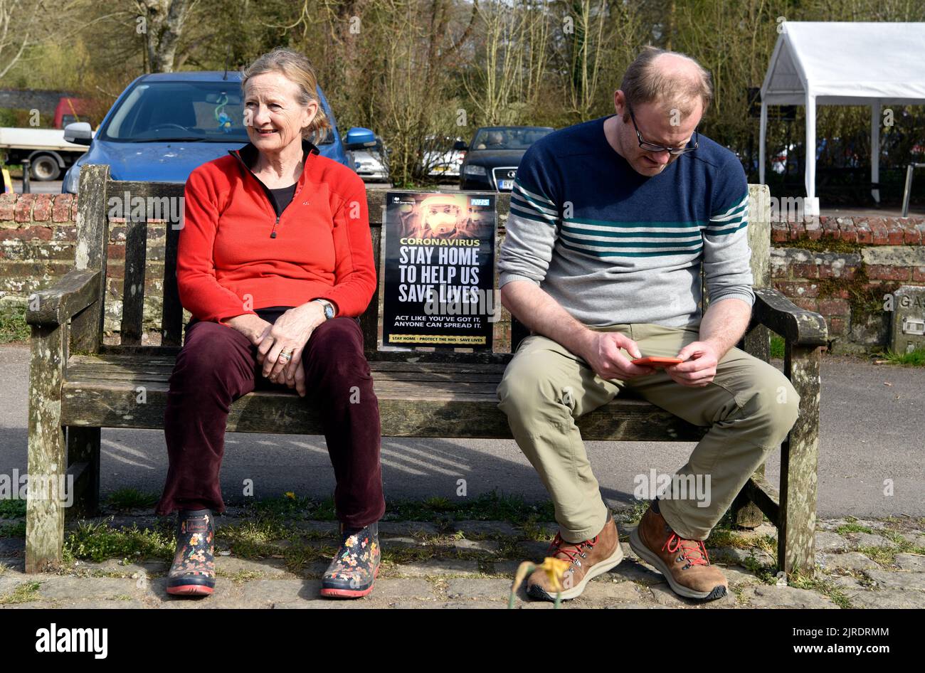 2 people sitting on a bench during COVID-19 lockdown, Chawton, Hampshire, UK. Stock Photo