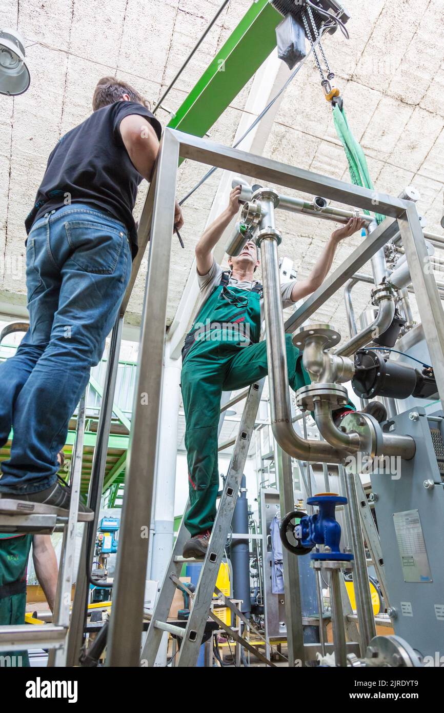 Industrial worker and mechanical engineer designing and measuring