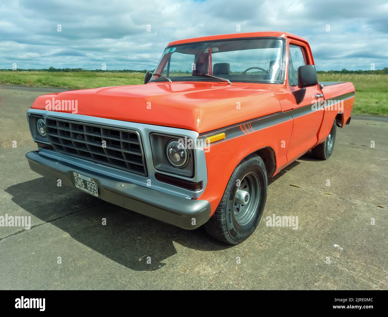 Moron, Argentina - Mar 26, 2022: old orange Chevrolet Chevy C 10 pickup truck 1970s by GM parked on an airstrip. Classic car show. Stock Photo