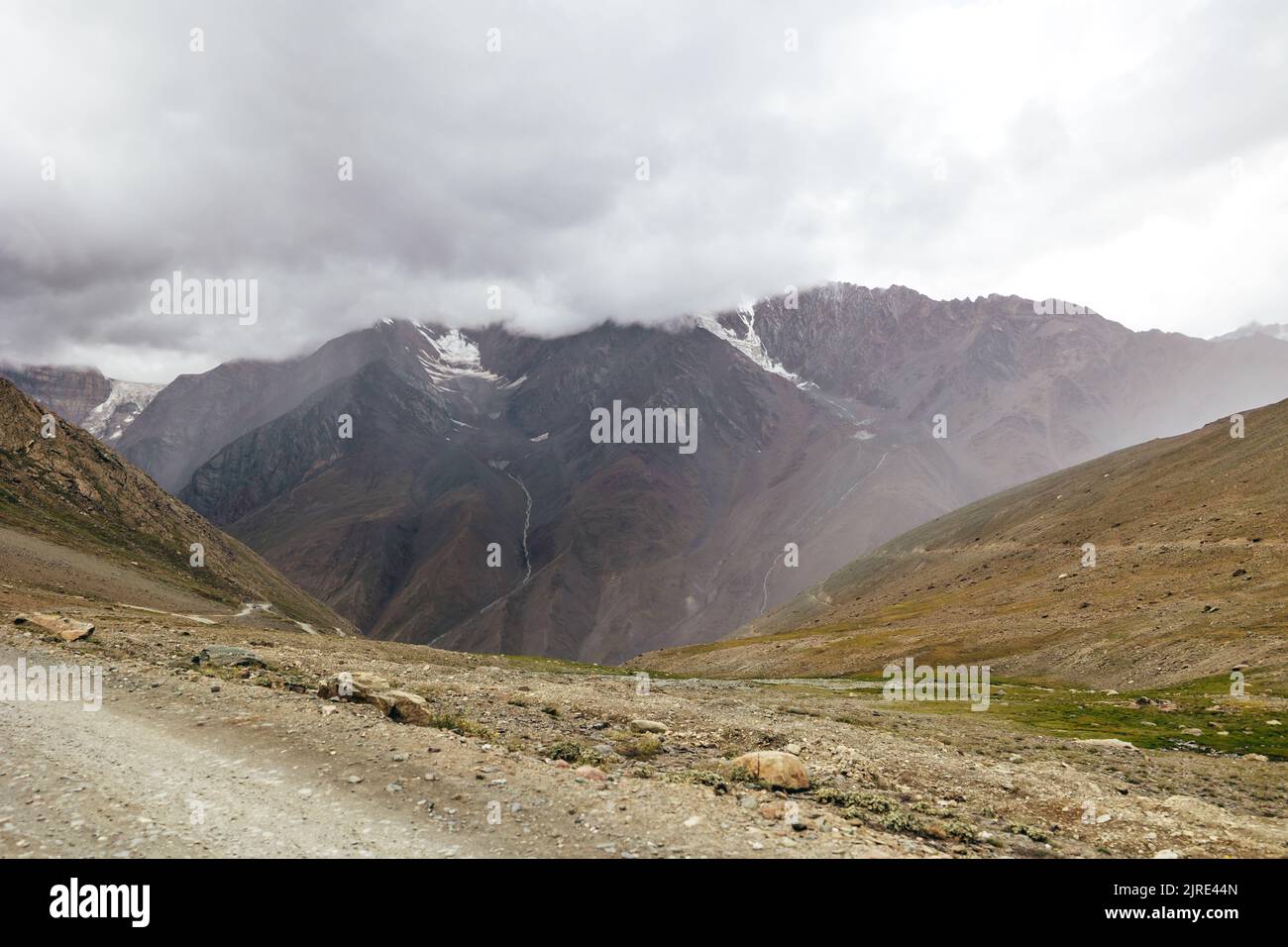 dark stormy clouds over snow peak Himalayan Mountains at Kunzum Pass in Himachal Pradesh India Stock Photo