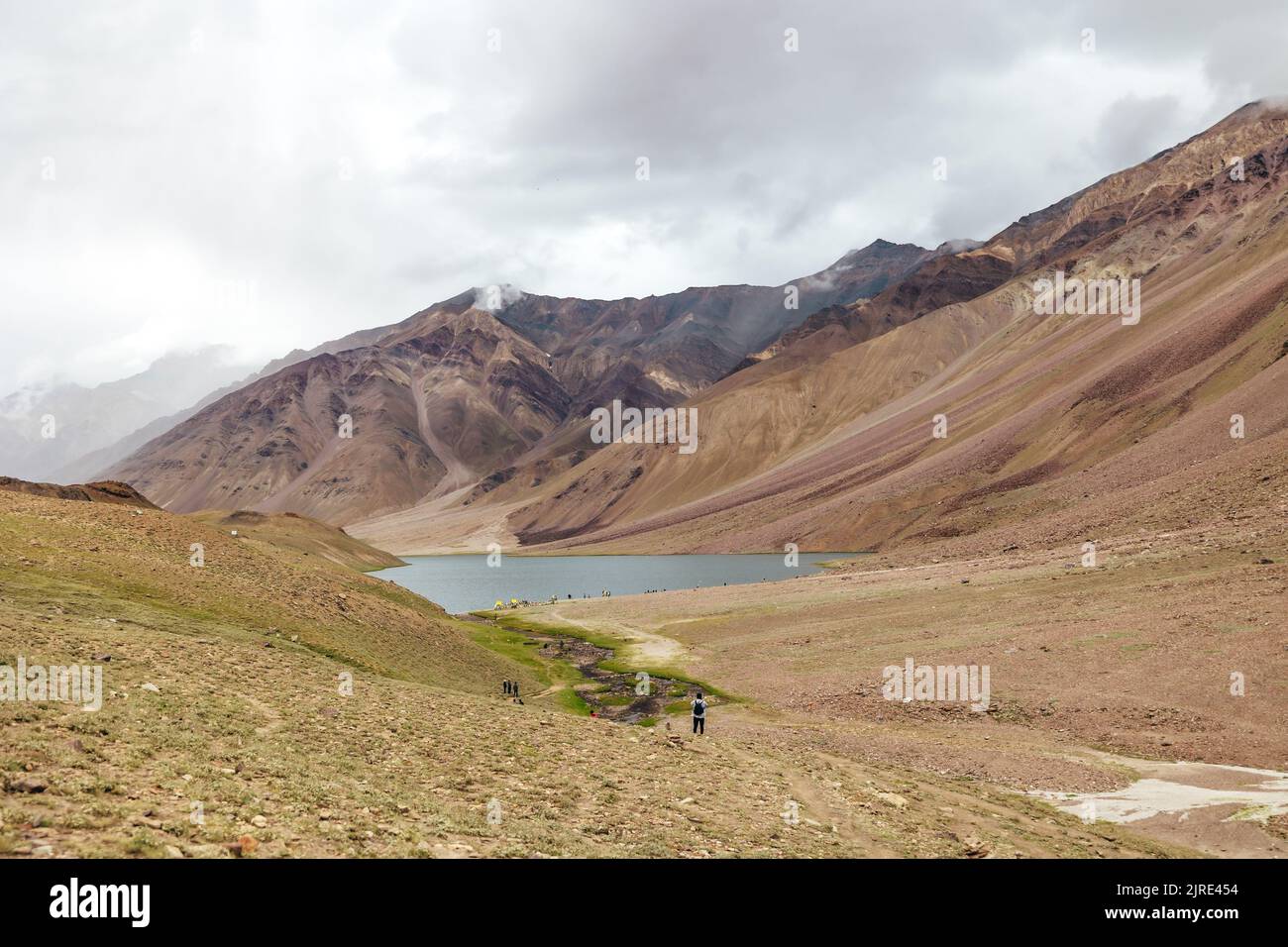 wide landscape of Chandra Taal lake with storm clouds over the mountain in Spiti Valley India Stock Photo
