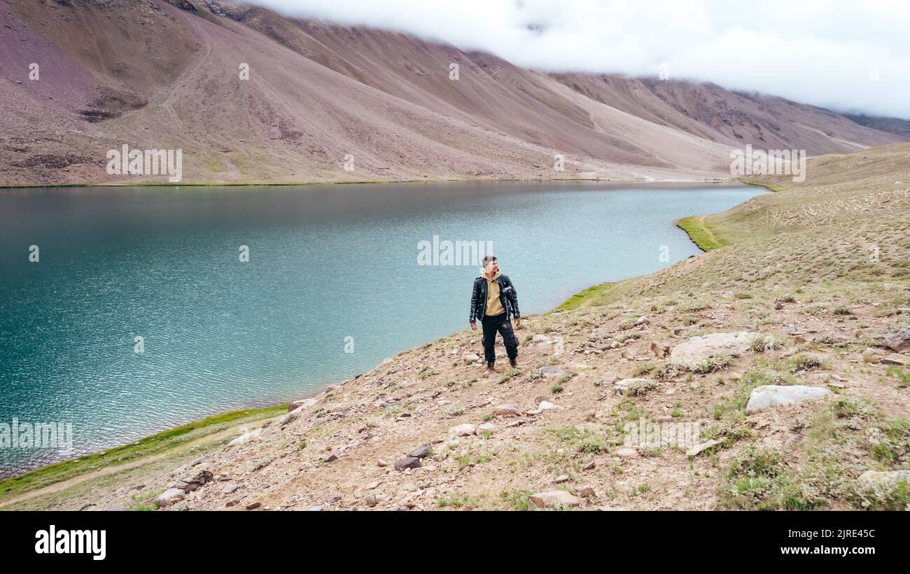 man at Chandra Taal Lake with no tourists on cloudy day in Spiti Valley India, landscape Stock Photo