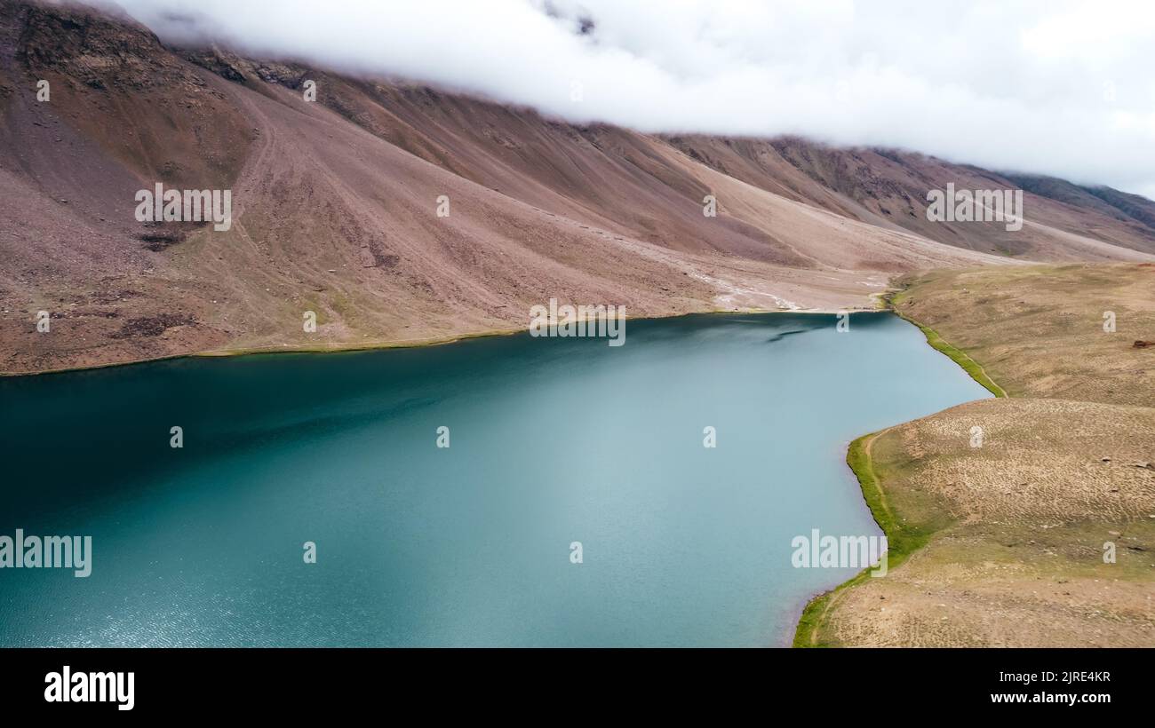 wide aerial landscape of Chandra Taal Lake in Spiti Valley of Himachal Pradesh on cloudy day Stock Photo