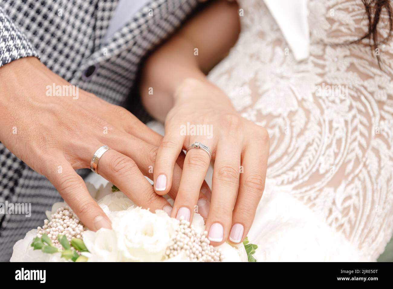 Newlyweds holding hands, holding hands in foreground, closeup of young