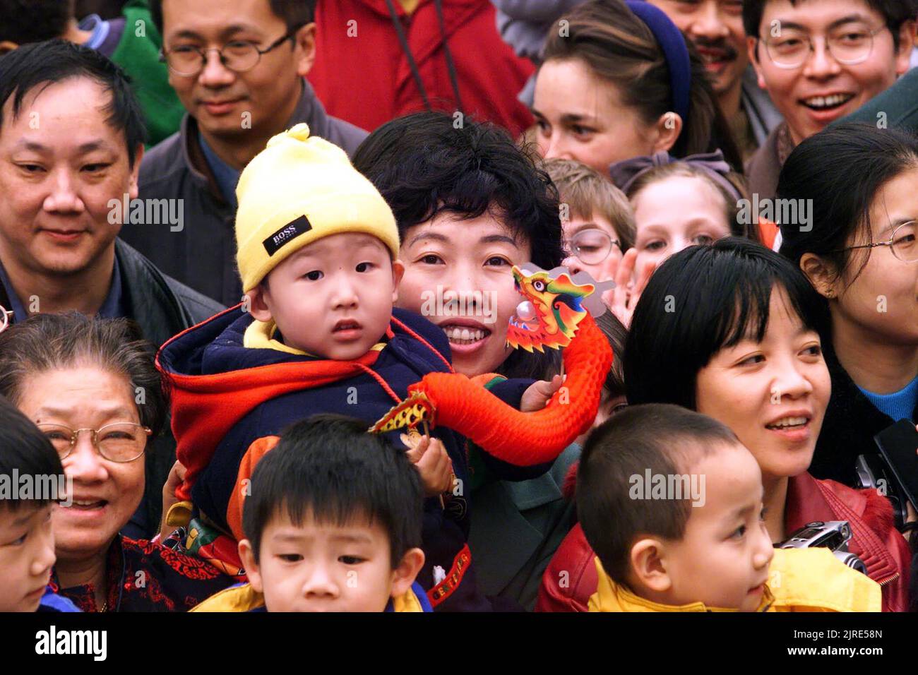 SMILING FACES IN THE CROWD IN MANCHESTERS CHINA TOWN AS THE LOCAL CHINESE COMMUNITY WELCOME THE CHINESE NEW YEAR THE YEAR OF THE GOLDEN DRAGON. MANCHESTER PICTURE GARY ROBERTS. Stock Photo