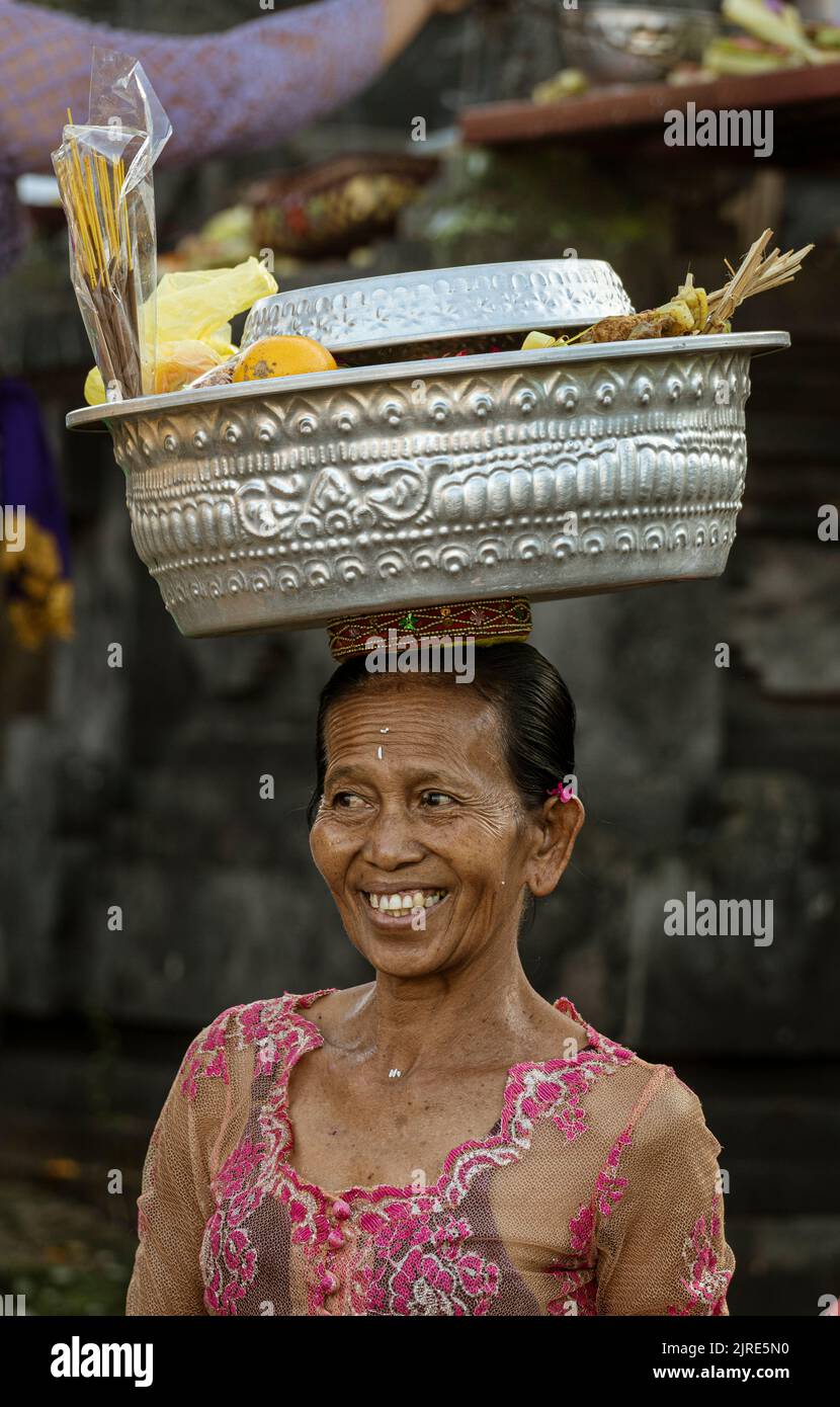 Woman carries basket on her head as she walks Stock Photo - Alamy