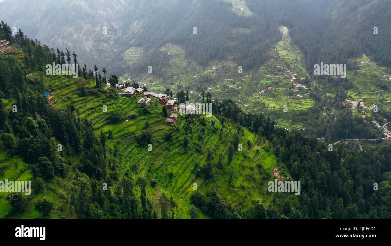 aerial top down of Jibhi mountains on cloudy afternoon and homes overlooking the valley Stock Photo