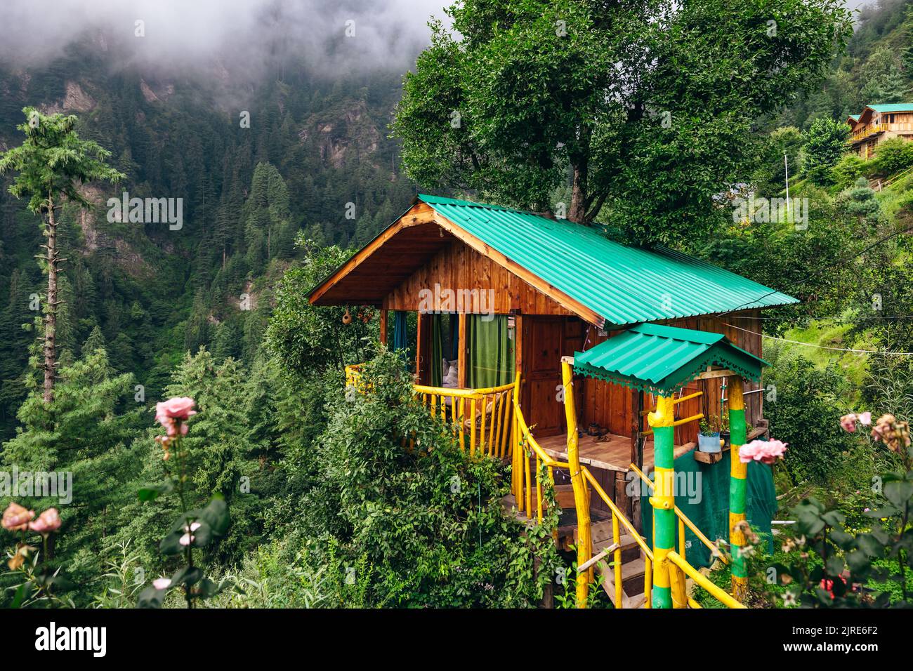 Magical wooden treehouse in the mountains of Jibhi India with moody clouds and cedar trees Stock Photo
