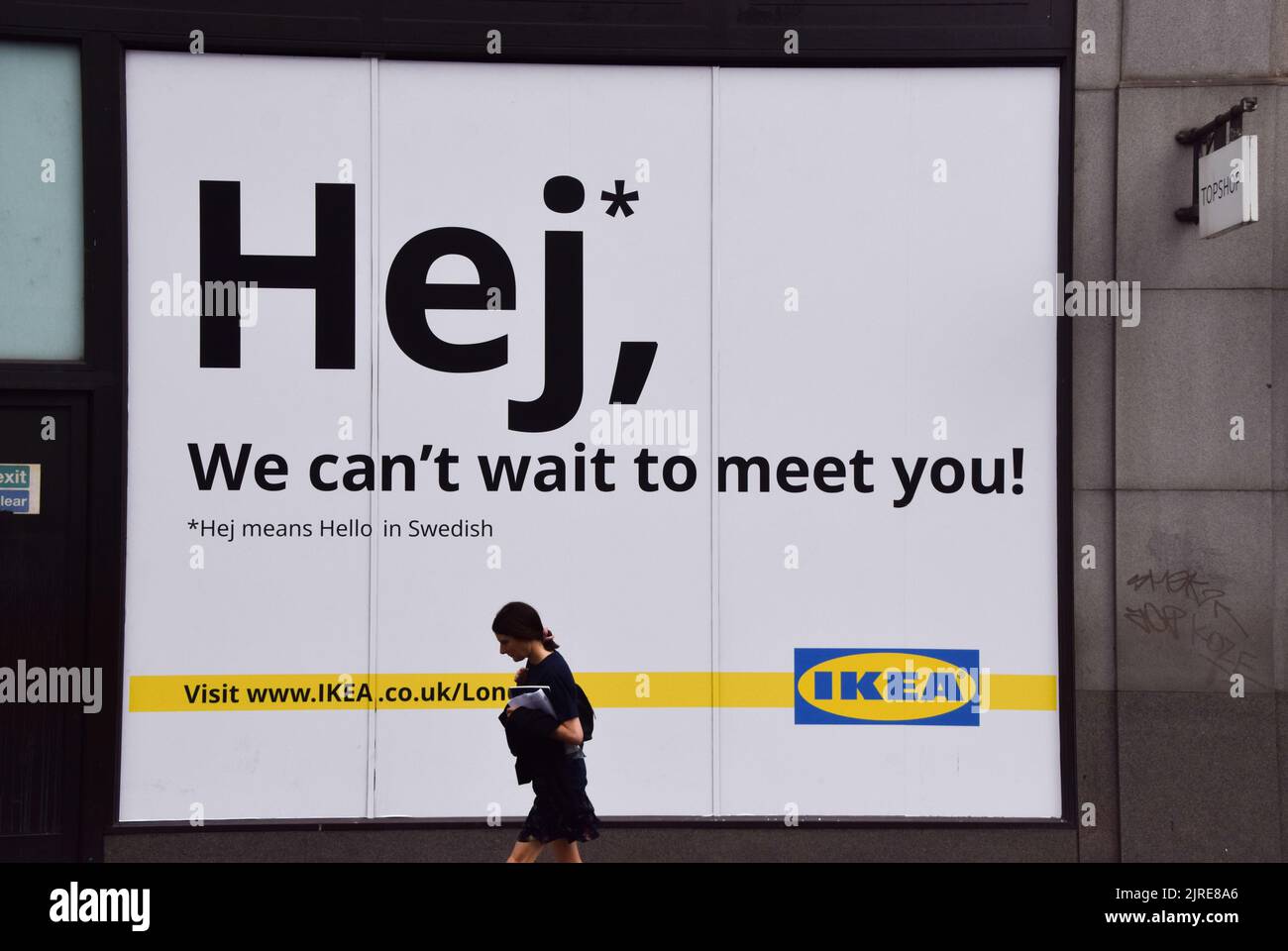 London, UK. 24th August 2022. A woman walks past the shop window of the