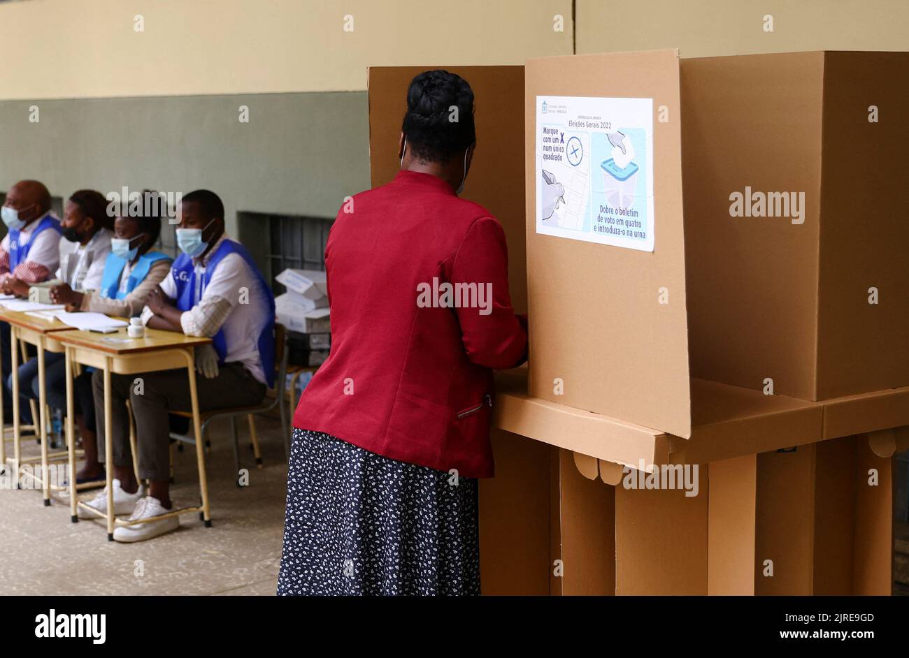 A woman casts her vote as election officials look on during the general election at Nzinga Mbandi school, in the capital Luanda, Angola August 24, 2022. REUTERS/Siphiwe Sibeko Stock Photo